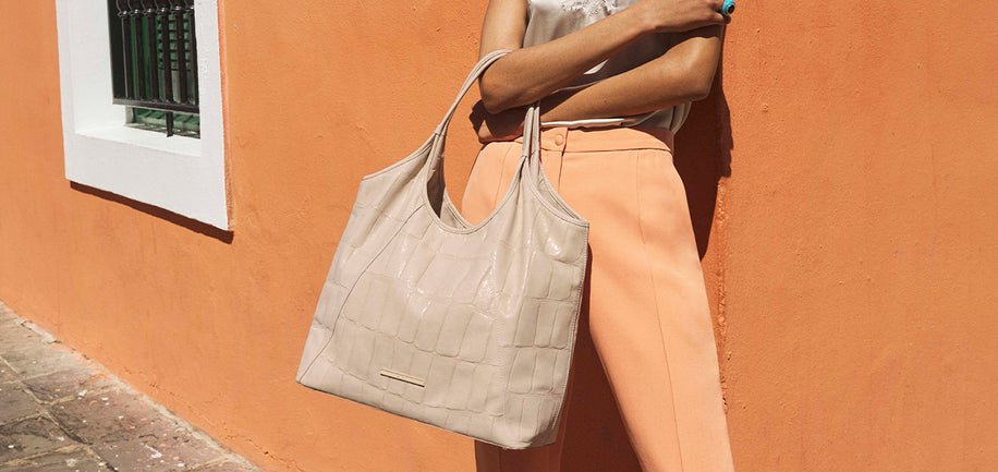 Beige Faroe Iona on model leaning against an orange wall