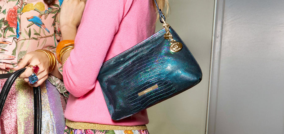 Model holding a blue handbag with a neutral background