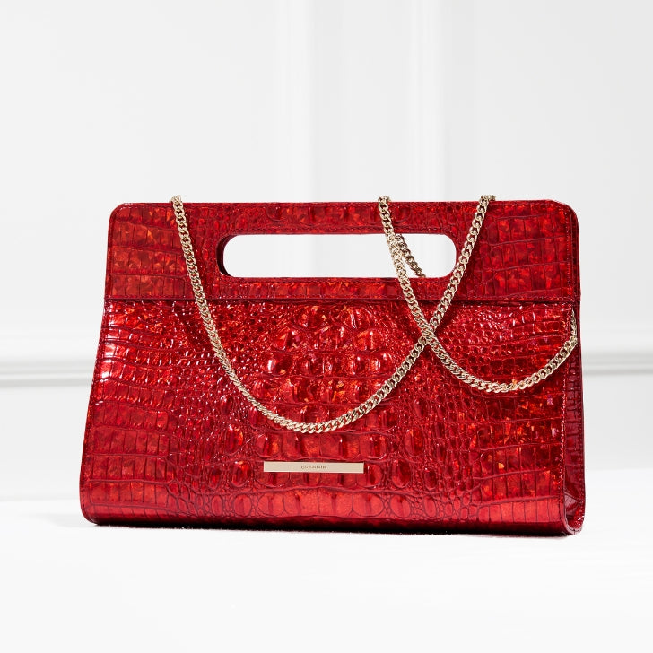 Red crocodile-embossed leather clutch with gold chain strap, structured evening handbag on white background