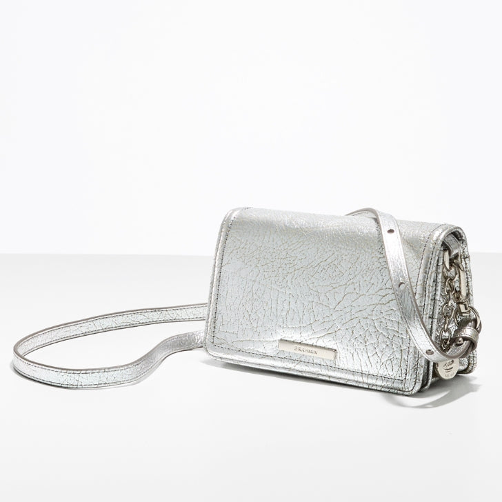 Silver metallic leather crossbody bag with adjustable strap, compact evening purse on white background