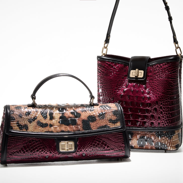 Two Brahmin handbags in rich berry and leopard-print croc-embossed leather, including a structured top-handle satchel and a matching shoulder bag with gold turn-lock hardware, photographed on a white studio background.