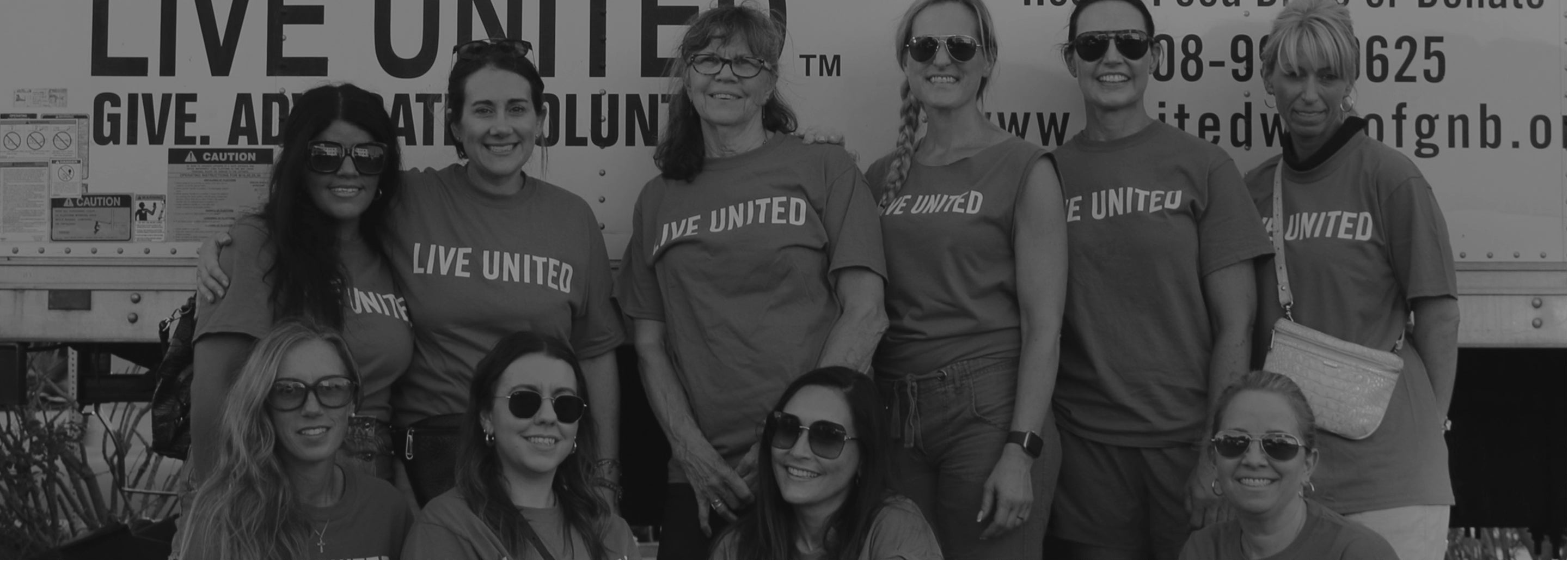 Group of people wearing 'Live United' shirts in front of a United Way truck.